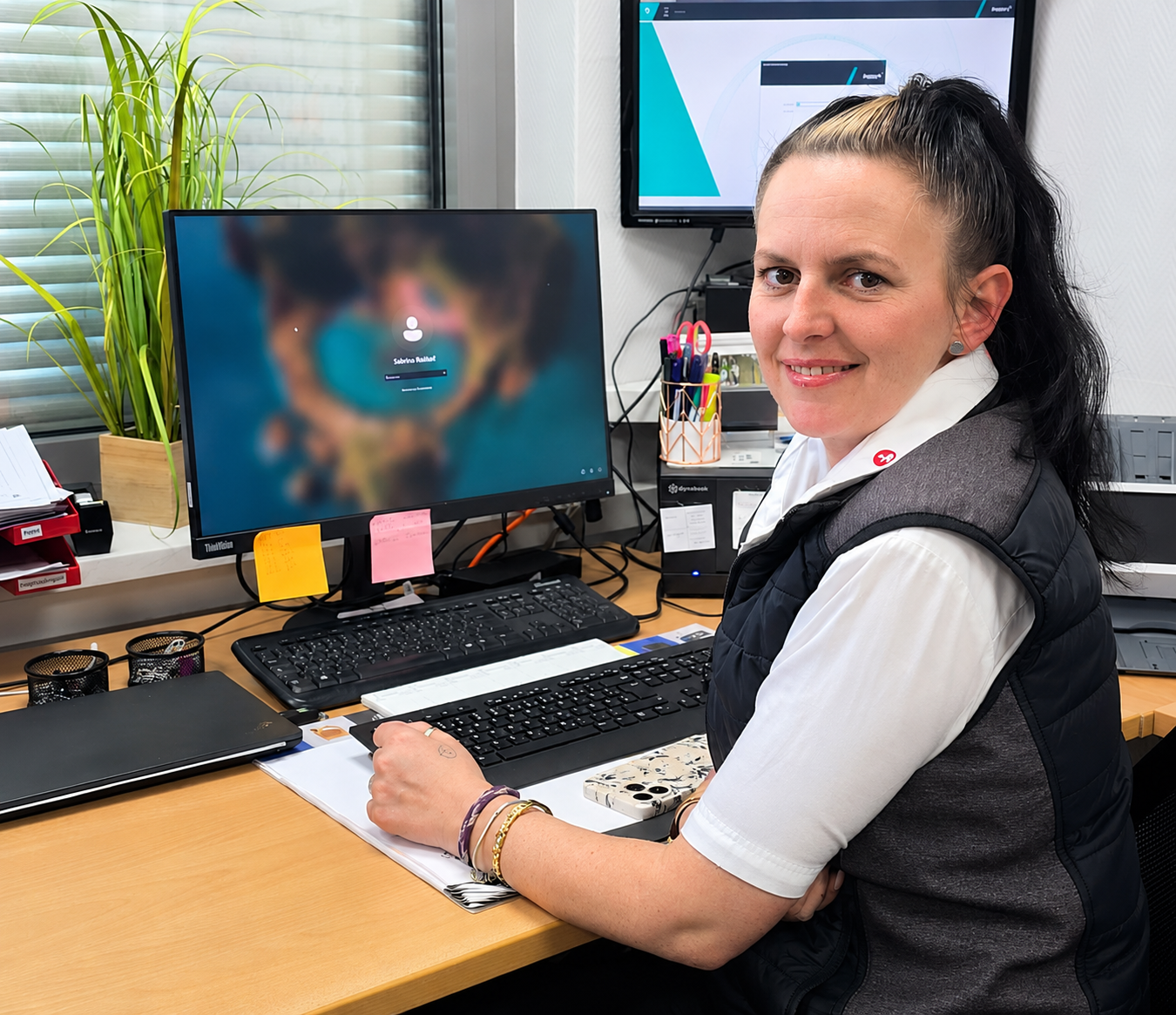 Sabrina R., Storemanagerin bei Reisdorf, sitzt an ihrem Arbeitsplatz im Büro und gibt Einblick in ihren Arbeitsalltag am Standort Rohnetal Nord und Süd.